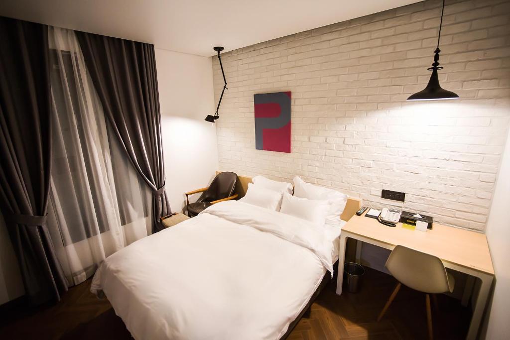 a hotel room with a bed and a desk with at Boutique Hotel Wine in Gwangju