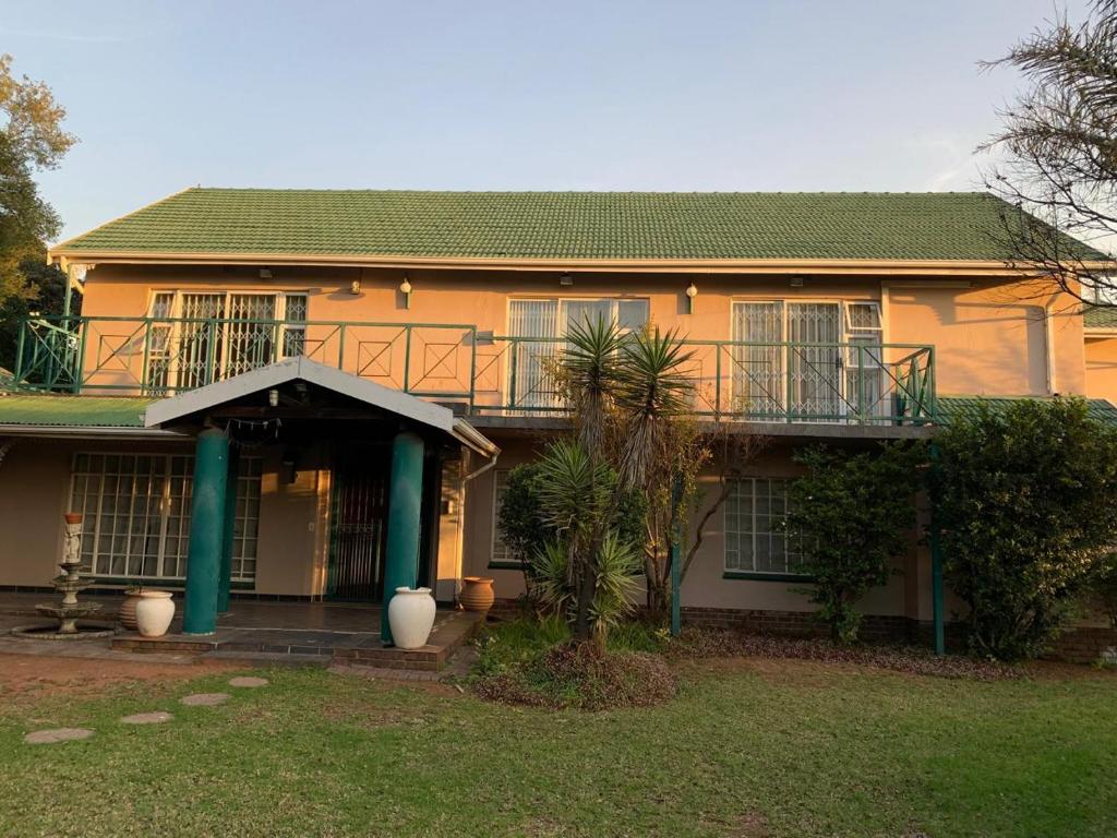 una casa gialla con portico e balcone di Florida Cloud 9 a Roodepoort