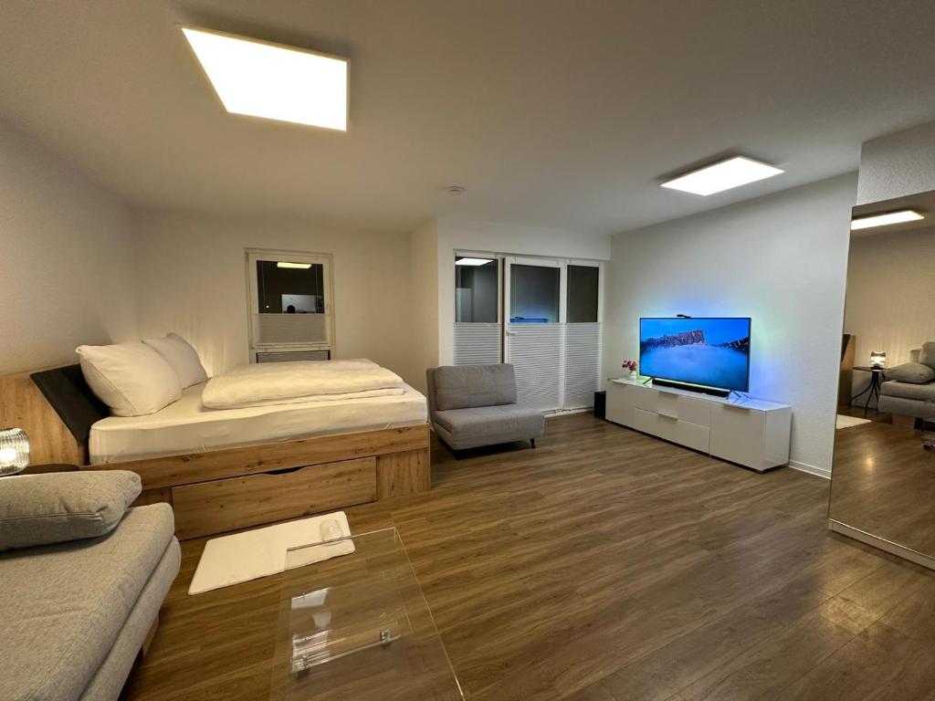 a bedroom with a bed and a tv and a couch at Anacoco Suites in Würselen