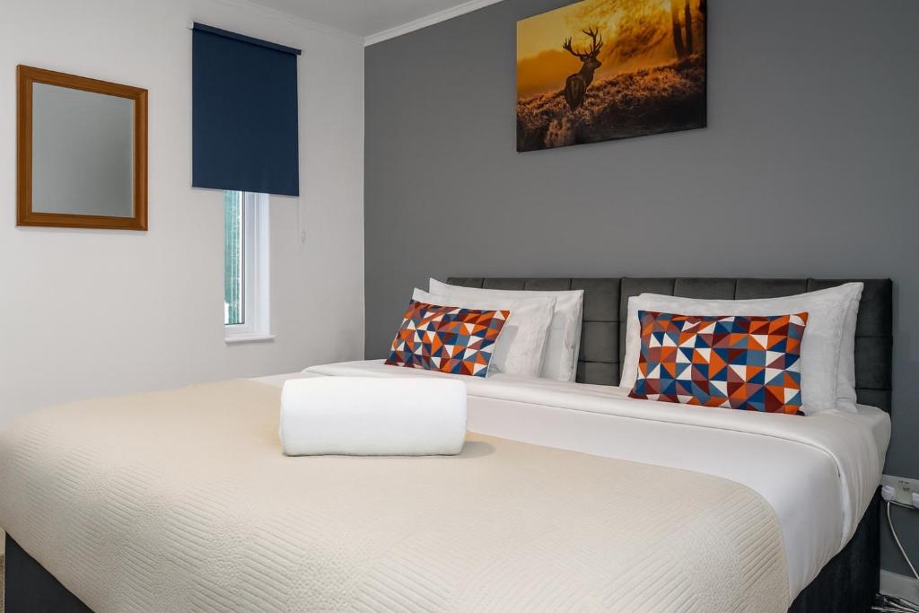 ein Schlafzimmer mit einem großen Bett mit zwei Kissen in der Unterkunft The Randolph 2-Bed MK9 Flat Short- Long-Stay Family & Contractor Friendly Free Parking close to Theatre, Now with lounge in Milton Keynes