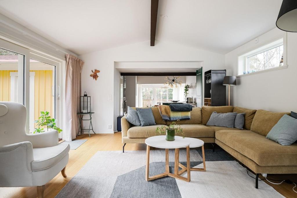 a living room with a couch and a table at Modern family home next to Mälaren in Mariefred in Mariefred