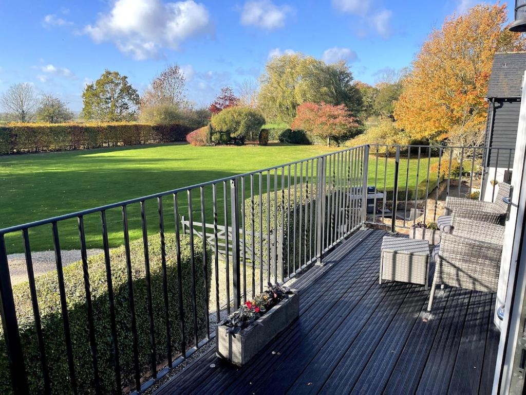 a porch with a fence and a lawn at Greenfinch Lodge in Norton Heath
