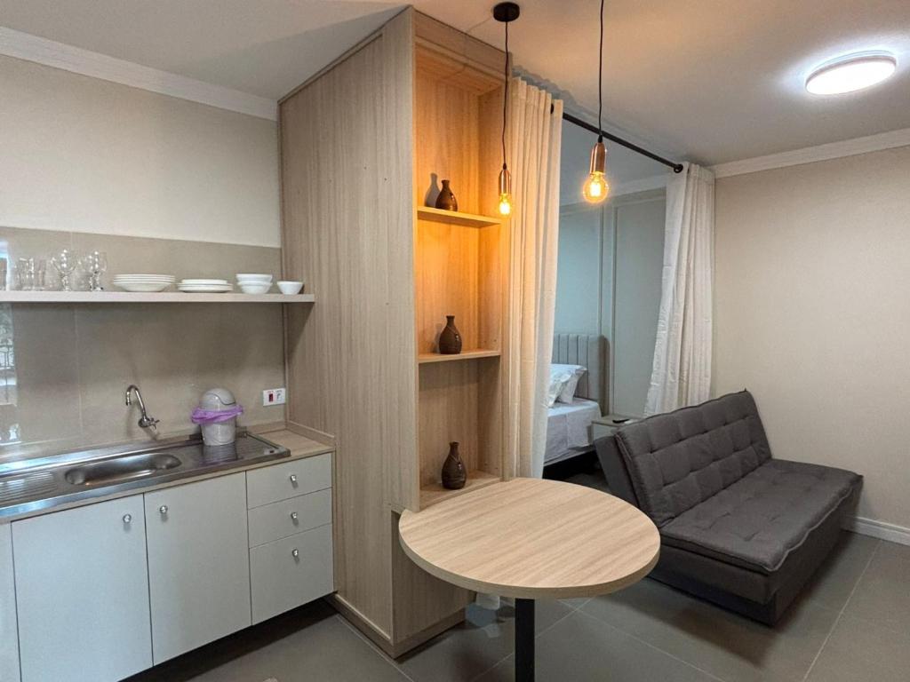 伊瓜苏Ravello Residencial - Próximo ao Paraguai e Centro de Foz do Iguaçu的厨房配有桌子、椅子和水槽