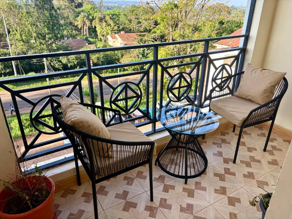 Un balcón con dos sillas y una mesa. en Loresho Luxe stay, en Nairobi