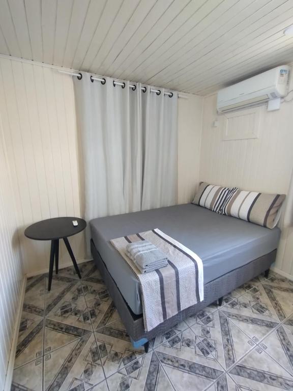 Pântano GrandeにあるChalé 138のベッドとテーブルのある小さな寝室