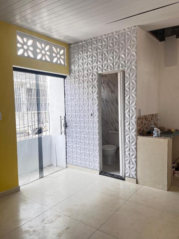 Cette chambre comprend une salle de bains pourvue de toilettes et d'une fenêtre. dans l'établissement Apartamento mobiliado - Próximo ao Estádio Olímpico do Mangueirão, à Belém