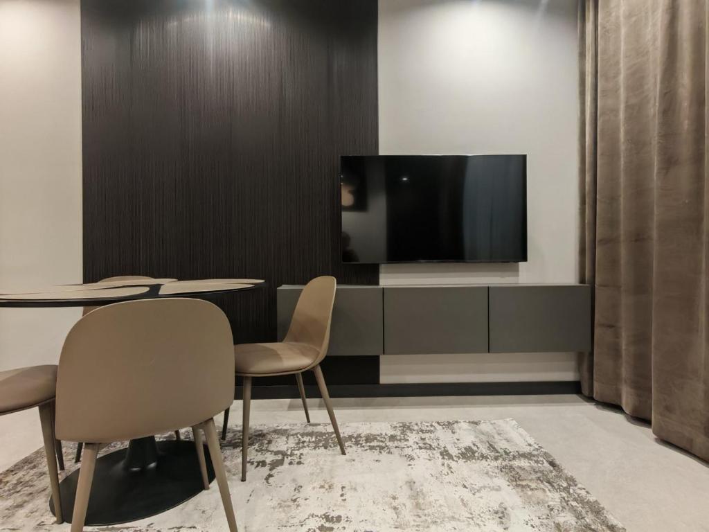een kamer met een tafel en twee stoelen en een televisie bij Апартамент Александровска in Boergas