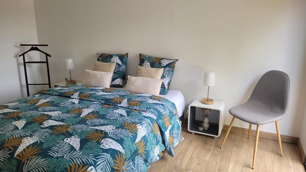 een slaapkamer met een bed en een stoel erin bij Gîte de la Côte Rouge in Saint-Nauphary