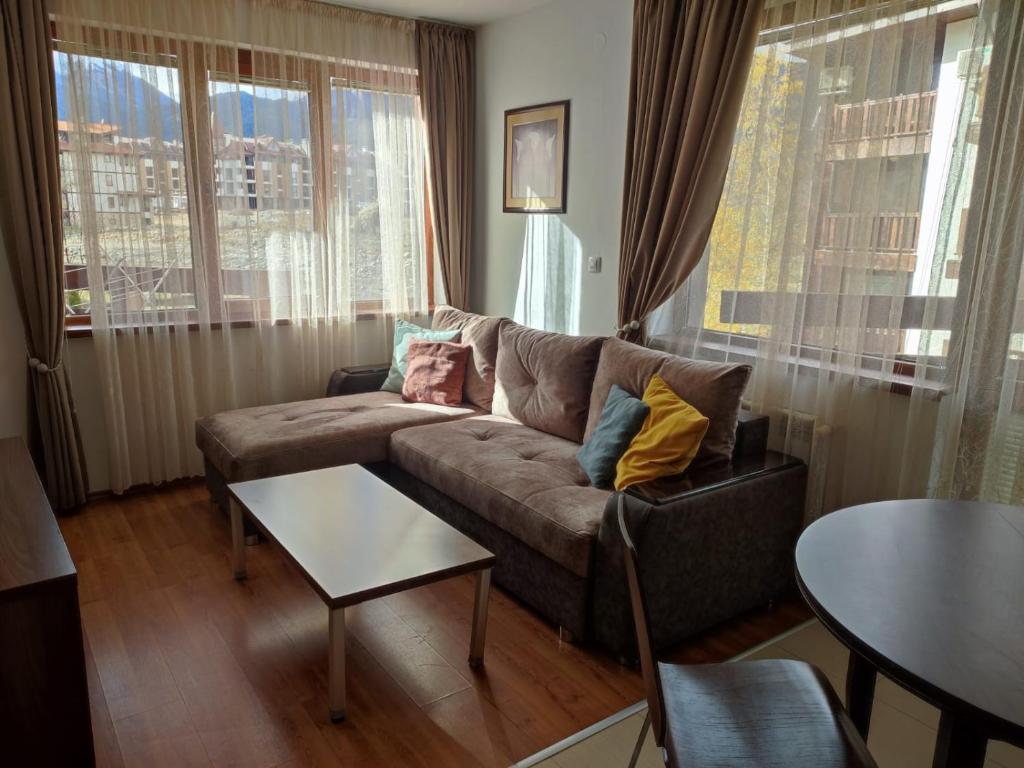 a living room with a couch and a table at Апартаменты в Belvedere in Bansko