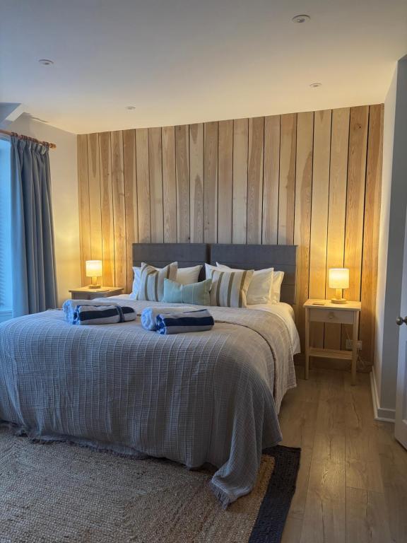 a bedroom with a large bed with wooden walls at Border View Cottage in Duddo