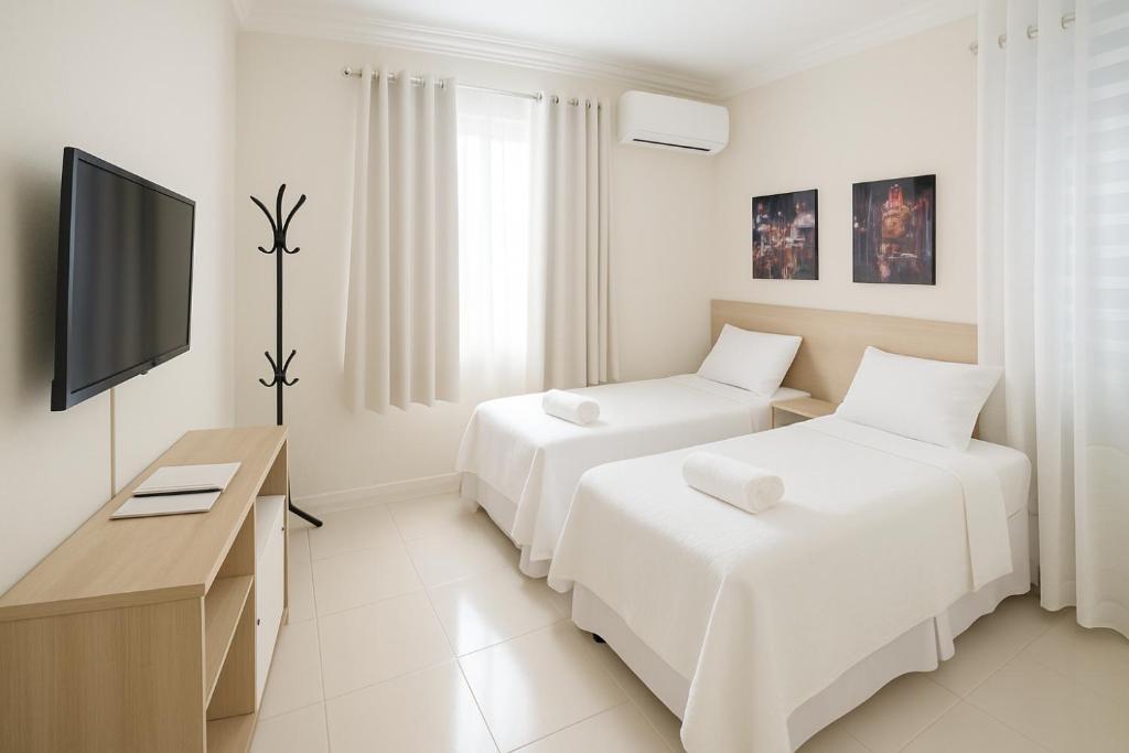a hotel room with two beds and a television at 218 Concept Hotel & Suites in Manaus