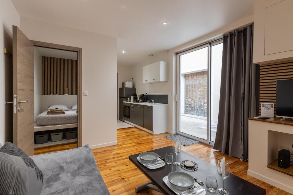 a living room with a couch and a table at L'Odile - 2 pers hypercenter in Bourg-en-Bresse