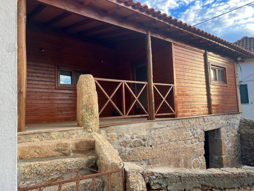a wooden house with a balcony on the side of it at Pérola da Serra in Fundão
