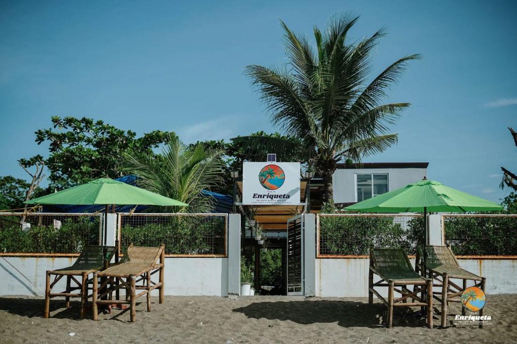 eine Gruppe von Stühlen und Sonnenschirmen an einem Strand in der Unterkunft Isla Enriqueta - Private Beach Resort in Iba
