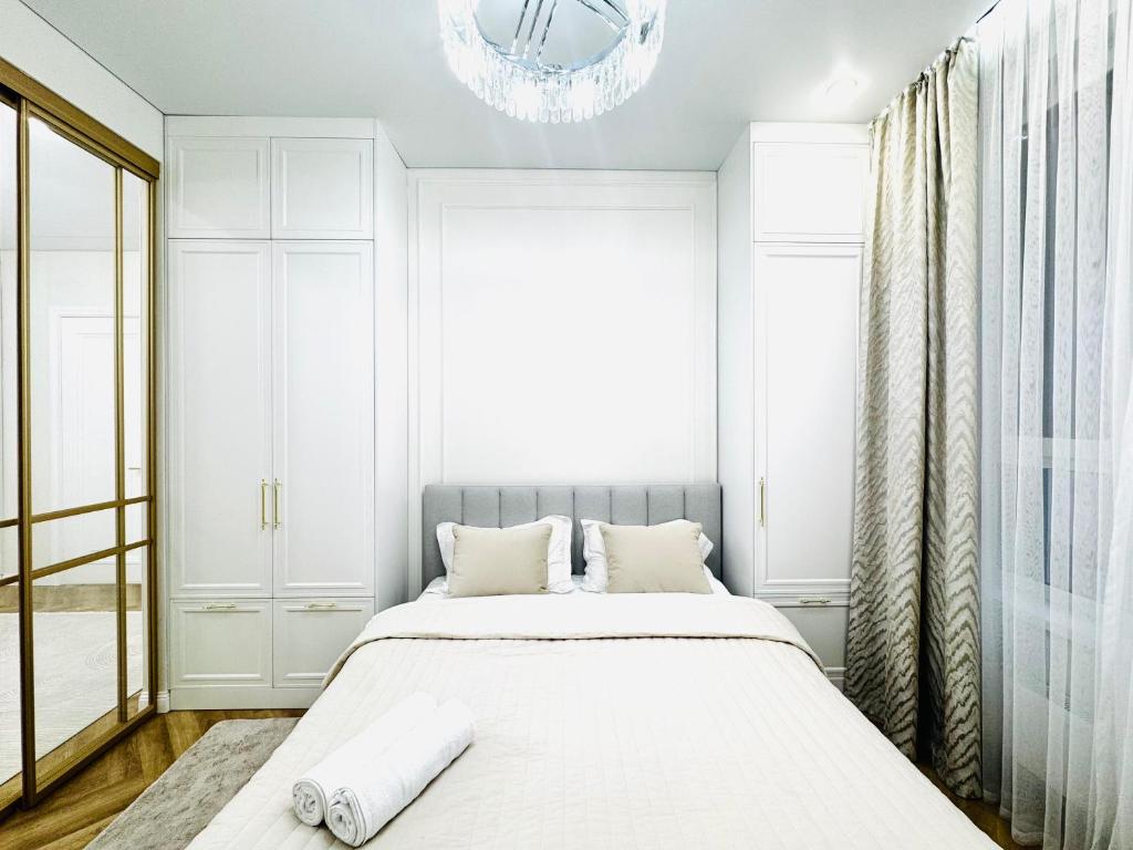 a bedroom with a bed and a chandelier at Respublica Luxe apart in Astana