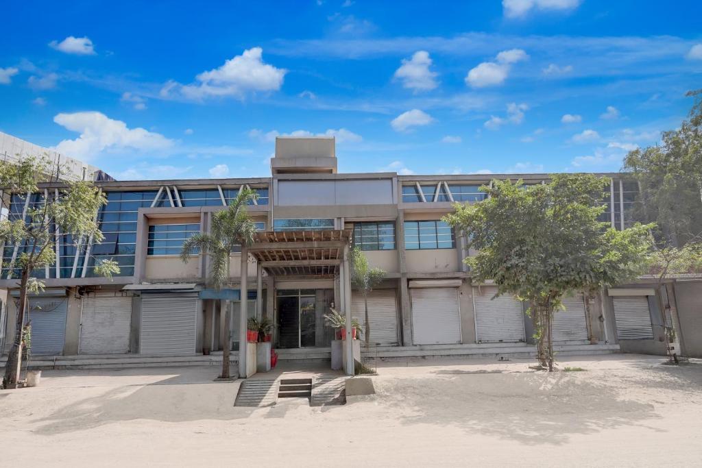 アーメダバードにあるHotel O Vatva Railway Station Formerly Anmol Palaceの前に木々があるアパート