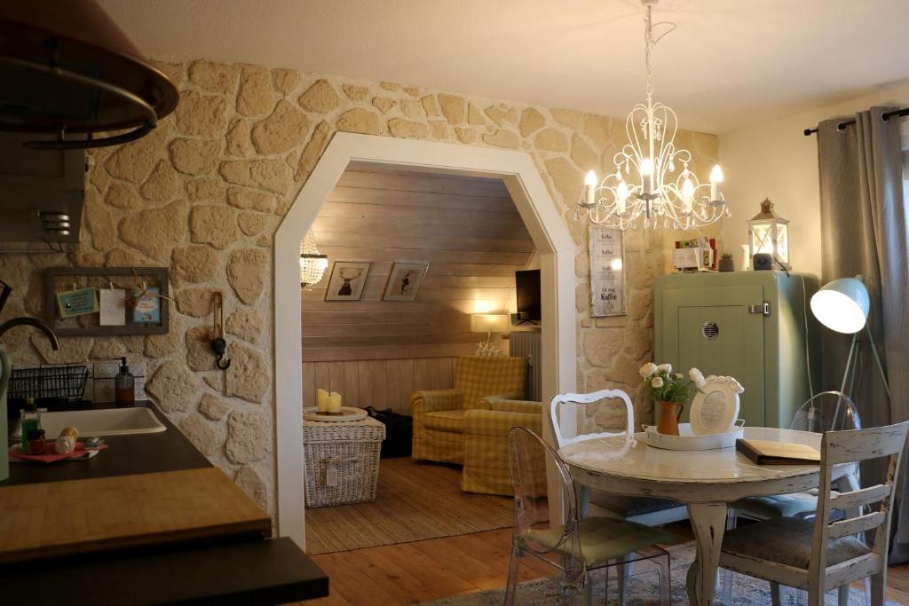 ein Esszimmer und ein Wohnzimmer mit einem Tisch und einer Küche in der Unterkunft Ferienwohnung Seeblick Nr 4 2 Zimmer, Bärental, Feldberg - a73042 in Rotwasser