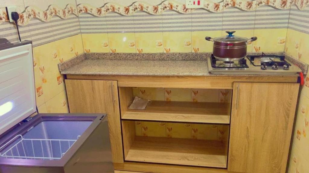 Una cocina con una encimera y una olla en la estufa. en House 40 Residence - Gold Mini Flat, en Ibadán