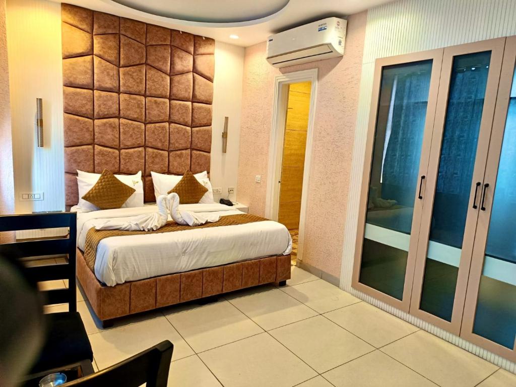a bedroom with a large bed and a balcony at The Silk Route Hotel in Panchkula