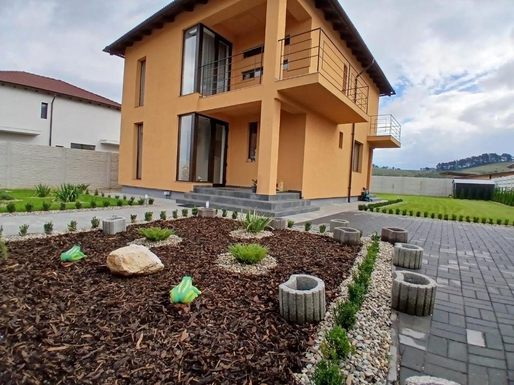 a house with a garden in front of it at Lux - Confort in Sînpetru