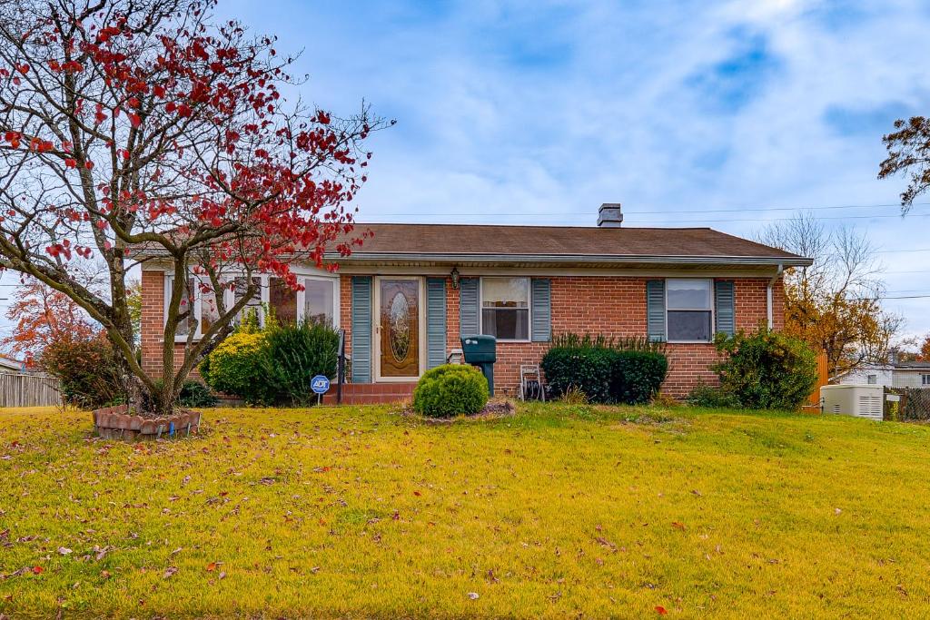a red brick house with a tree in the yard at 2 Mi to APG Edgewood Family Home with Fenced Yard in Edgewood