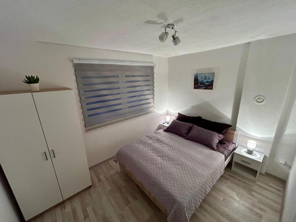 Un dormitorio con una cama y un ventilador de techo. en Apartman M, 