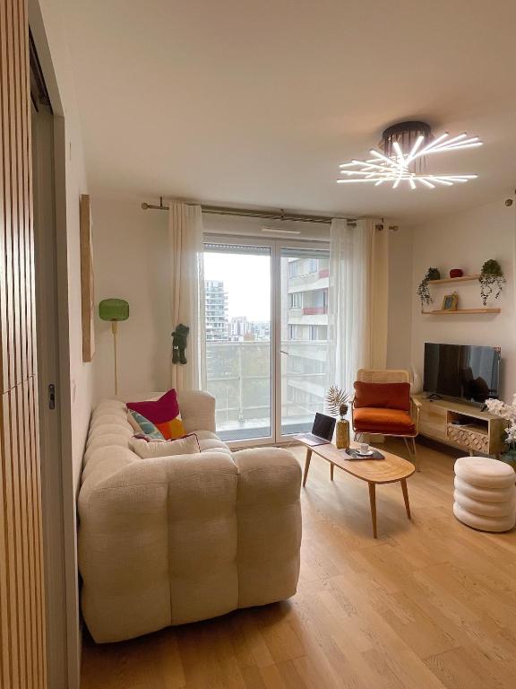 a living room with a couch and a table at Ins apartment - 2 bedrooms - metro parking prive in Bagnolet