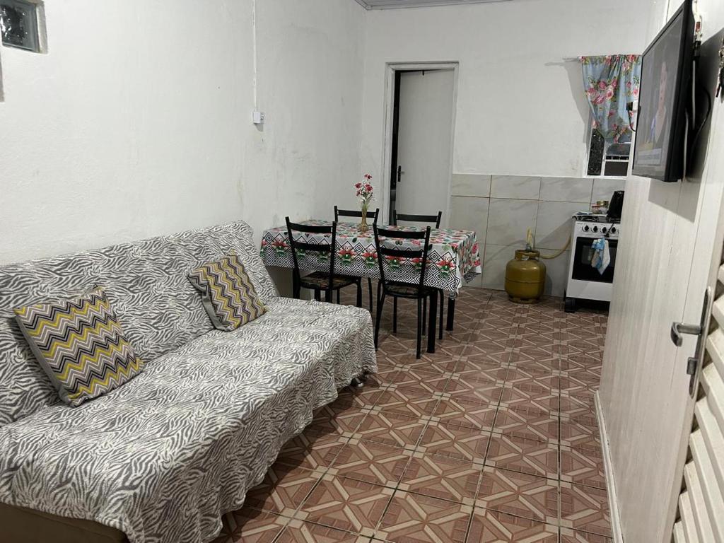 ein Wohnzimmer mit einer Couch und einem Tisch und Stühlen in der Unterkunft Casa perto da Expointer in Esteio