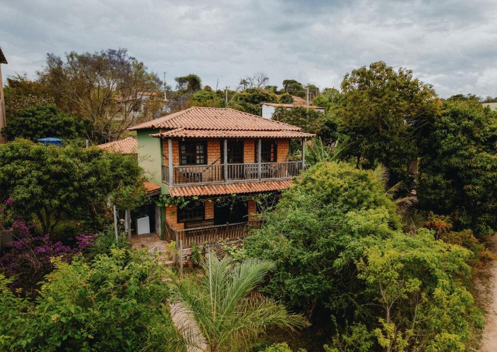 ein altes Haus mit Balkon in den Bäumen in der Unterkunft Casa em Milho Verde - Minas Gerais in Sêrro