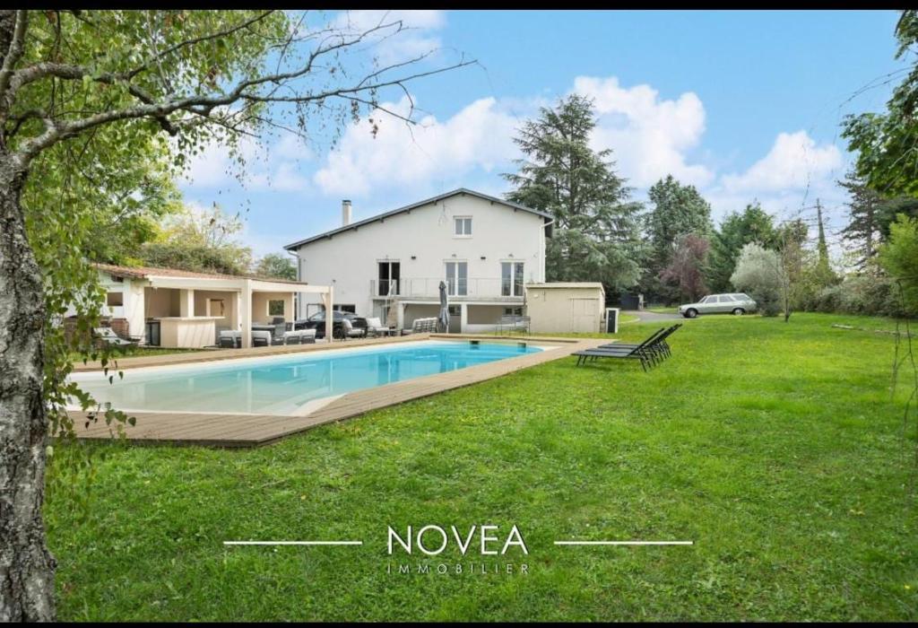 a house with a swimming pool in a yard at L'Écrin des Greens in Dommartin