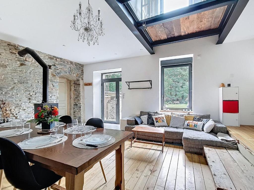 una sala de estar con una mesa y un sofá en Le Moulin Hochet, en Les Pieux