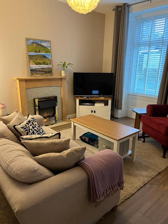a living room with a couch and a coffee table at Katys Cottage, Barnoldswick in Barnoldswick