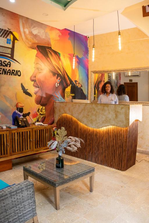 a restaurant with a large painting of a woman at Hotel Casa Centenario Getsemaní in Cartagena de Indias