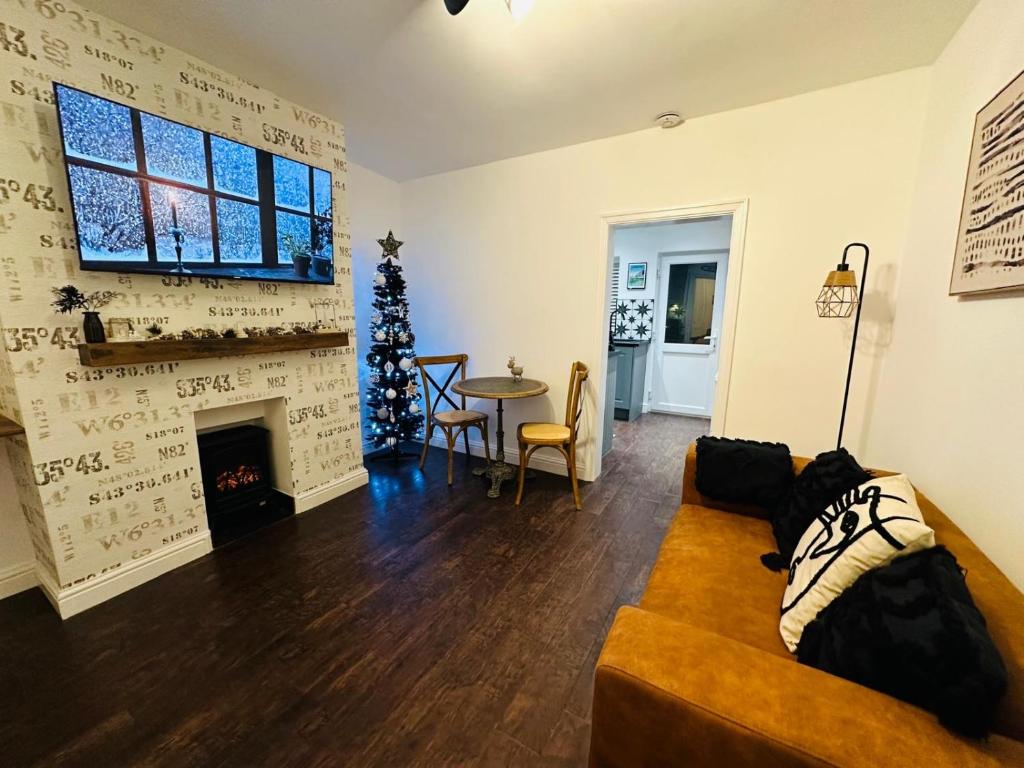 ein Wohnzimmer mit Couch und Kamin in der Unterkunft The Nook Cottage, Parkgate, Wirral in Parkgate