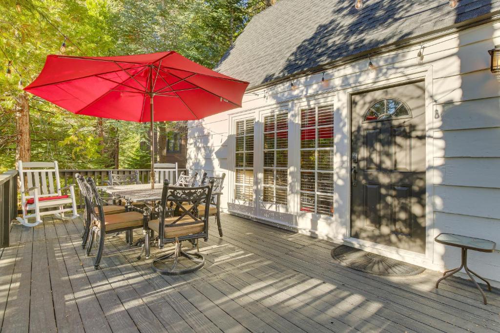 eine Terrasse mit einem Tisch und einem roten Regenschirm in der Unterkunft Private Dock on Lake Arrowhead! Cozy Mtn Cabin in Lake Arrowhead
