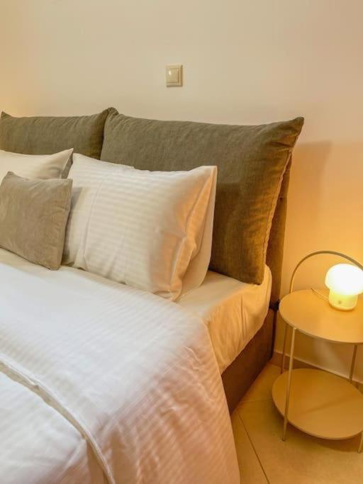 a bedroom with a bed with pillows and a table at Afroditi's Apartment Superb View in Gythio