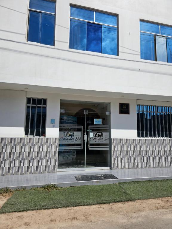 a white building with a large glass door at Hotel costa del Sol Marcona in San Juan de Marcona