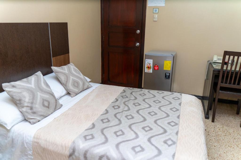 Un pat sau paturi într-o cameră la Urdesa Suites Hotel