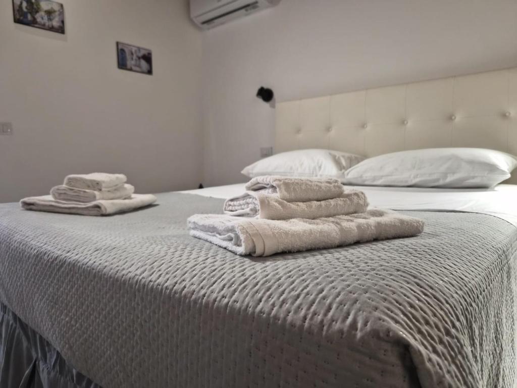 two stacks of towels sitting on top of a bed at Cattedrale Central Rooms in Palermo