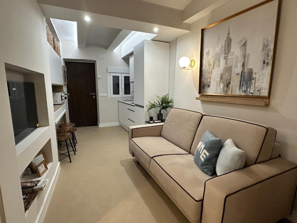 een woonkamer met een bank en een televisie bij Castillo 22 in Oropesa