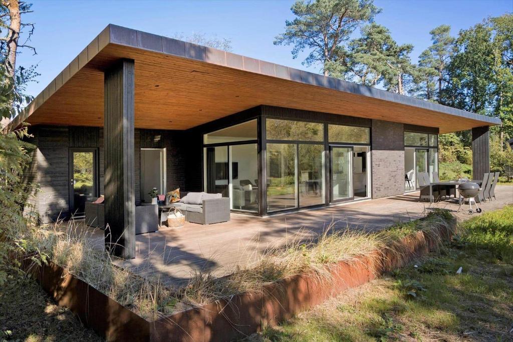 a house with large glass windows and a patio at 8244-Knebel-Metholmvej-20 in Knebel