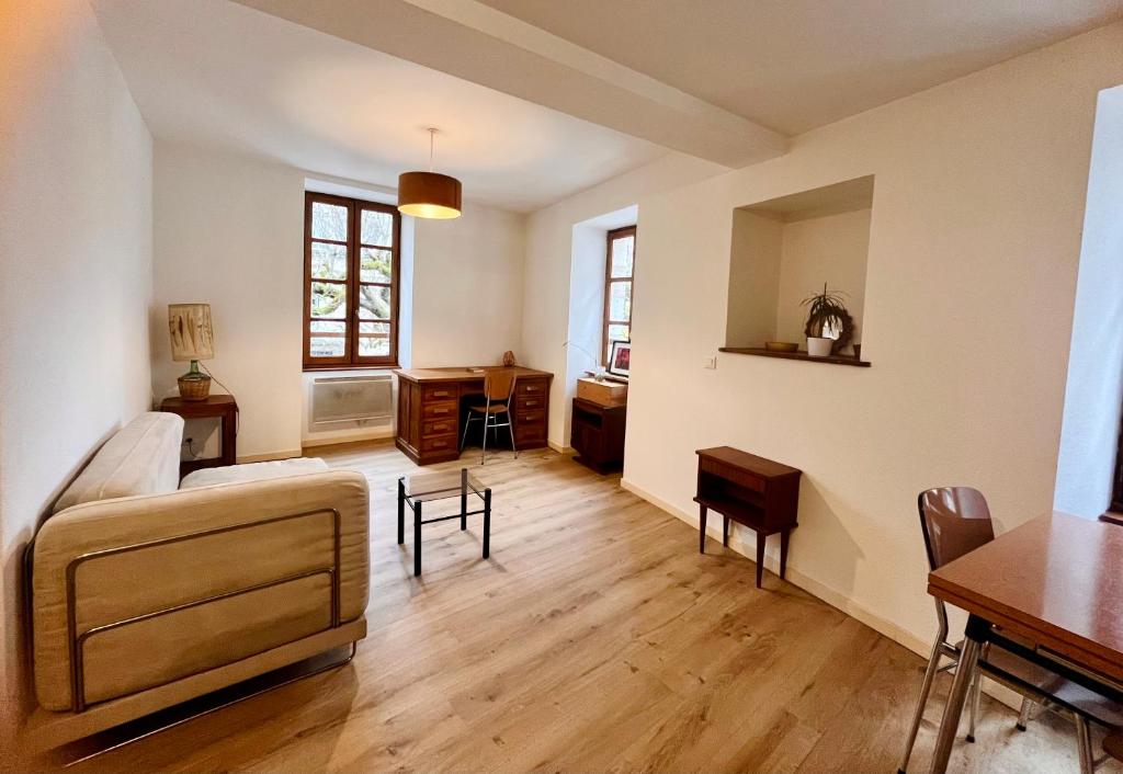 a living room with a couch and a table at Appartement minimaliste et cozy in Cajarc