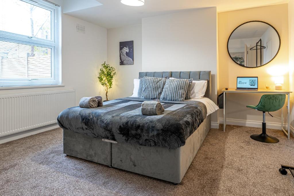 a bedroom with a bed and a desk and a mirror at Cosy Corner in Derby