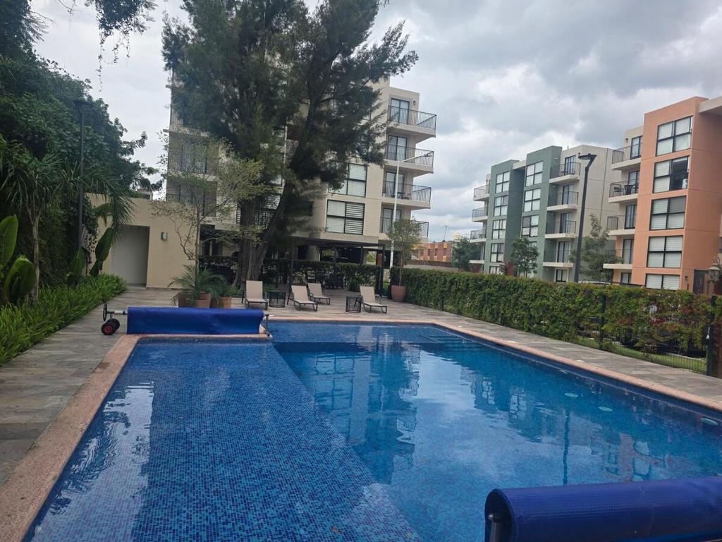 una piscina en medio de un edificio en Departamento con alberca, en Guadalajara
