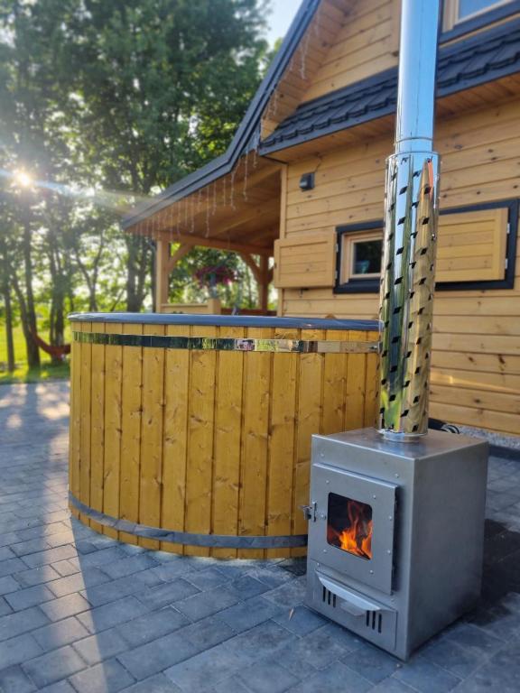 a wood stove in front of a house at BAJKA-Domek na wsi in Domaszków