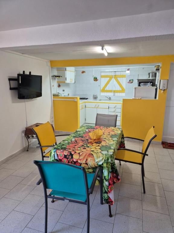 a dining room with a table and chairs and a kitchen at Villa Soleil DZ in Baillif
