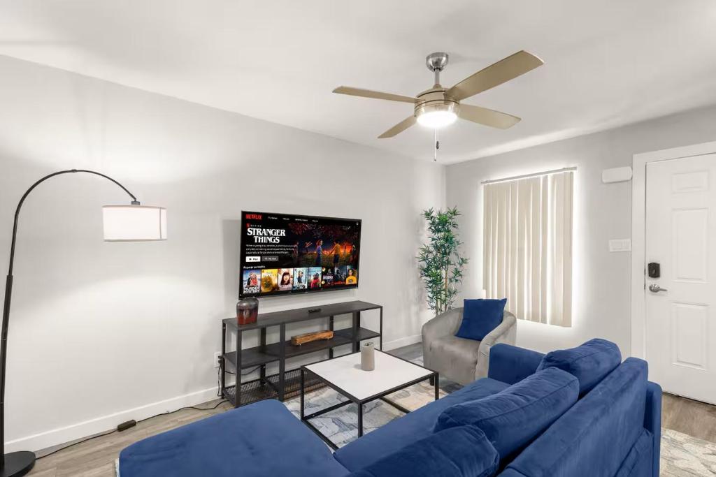 a living room with a blue couch and a tv at ATX Casa Tranquila in Austin