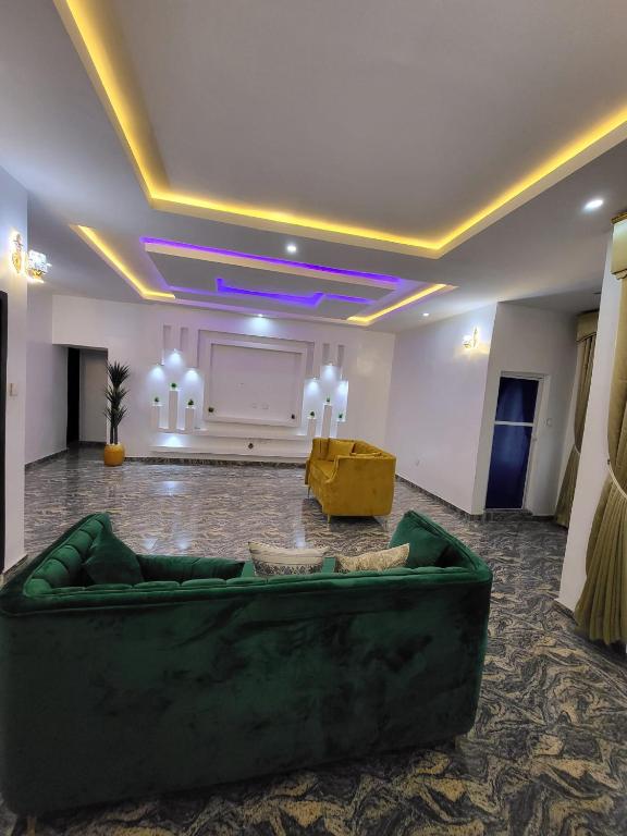 a large living room with a green couch in the middle at Trinity Apartments in Lagos