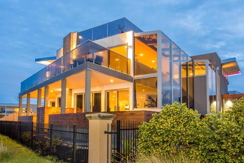 a large house with glass windows and a fence at Starhaven Retreat in Portarlington