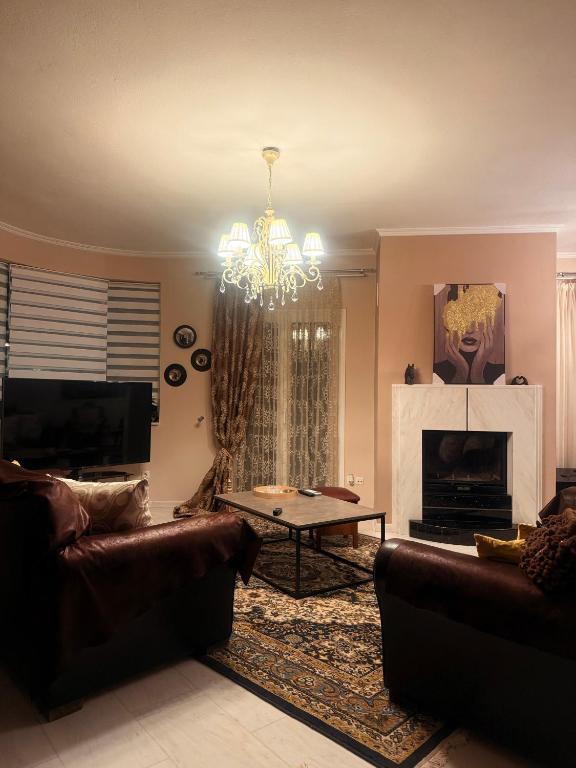a living room with a couch and a table and a chandelier at Plex House in Tríkala